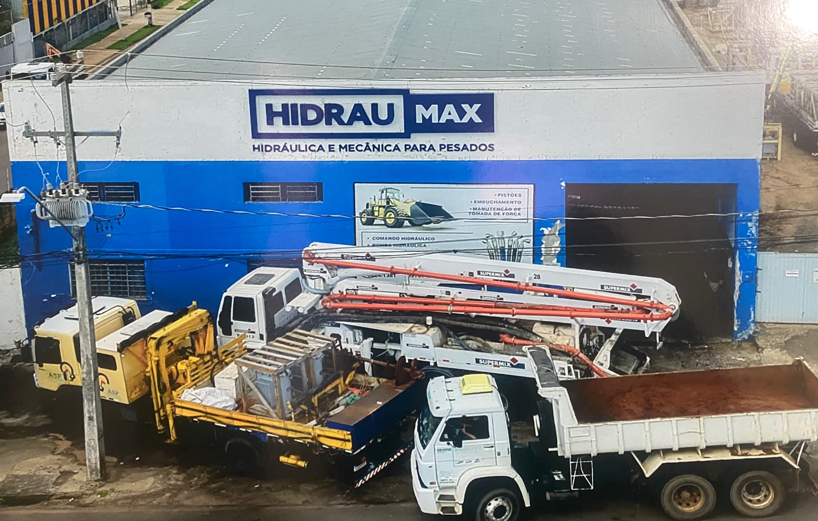 Estrutura da HidrauMax em Umuarama com caminhões e equipamentos pesados